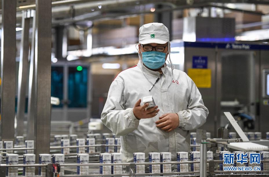 3月19日，技术人员在呼和浩特市蒙牛圣牧高科乳品有限公司的生产车间内检查产品的包装情况。新华社记者 彭源 摄