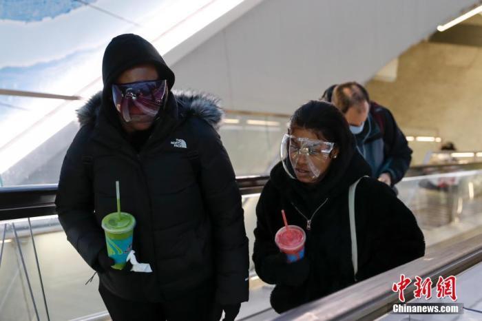 当地时间1月26日，美国纽约宾夕法尼亚火车站，戴着面罩出站的行人。中新社记者 廖攀 摄